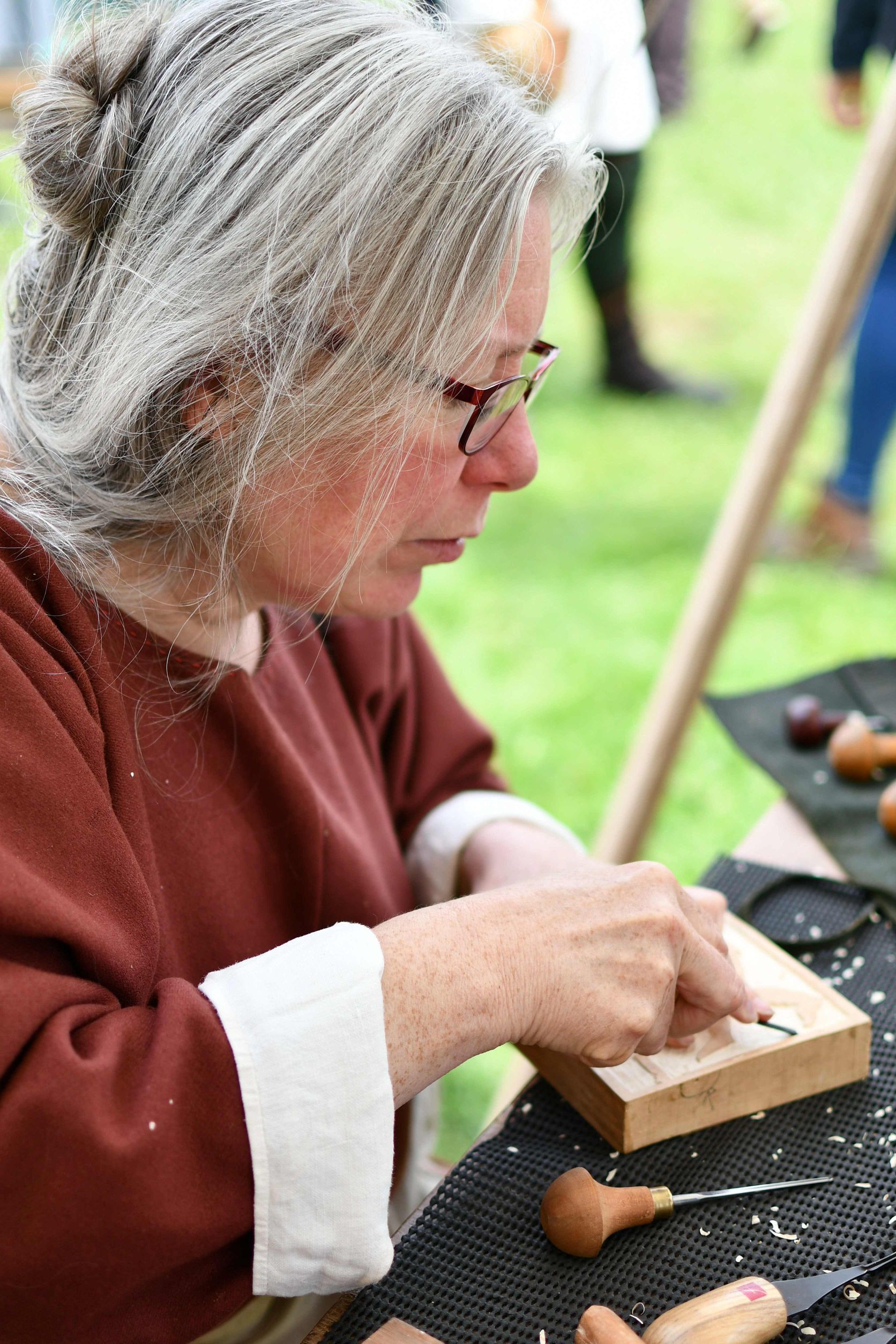 Karen Slade carving a wooden pattern block for a medieval tile found at Canterbury Cathedral. Photo by James Hazelwood 2018.